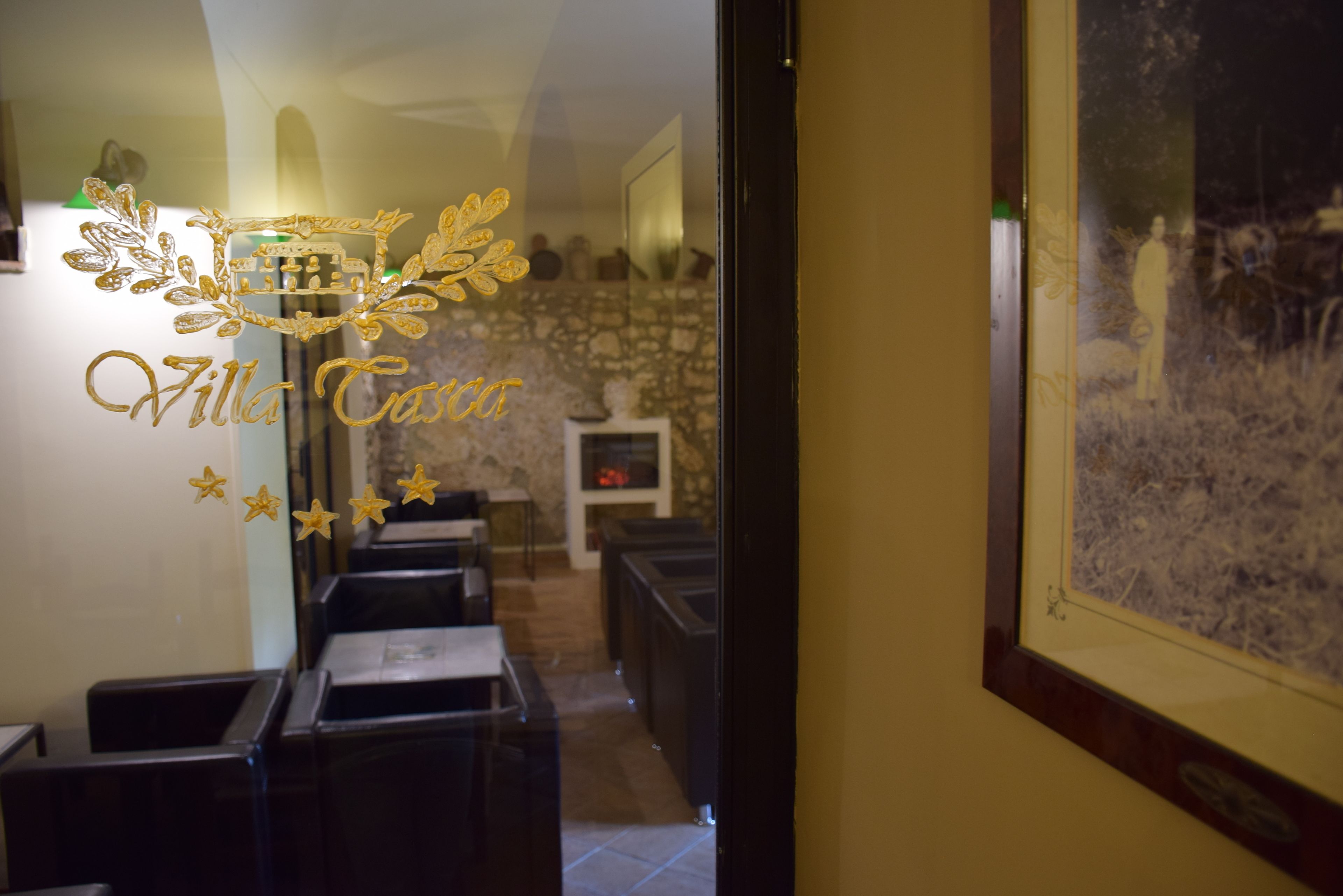 A hotel interior with a reception area, a stone wall, and a framed picture on the wall.