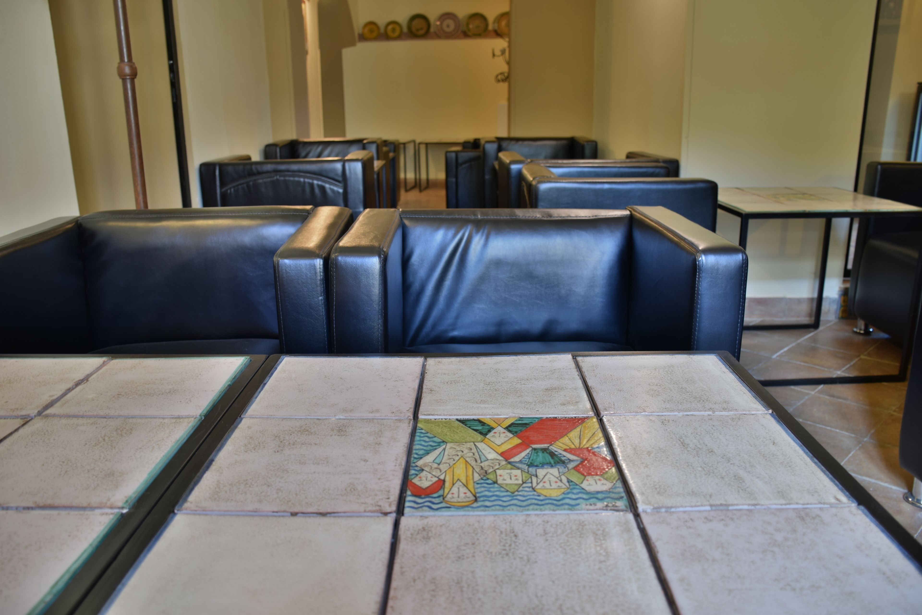 A restaurant with black leather booths and a tiled floor with a colorful geometric pattern.