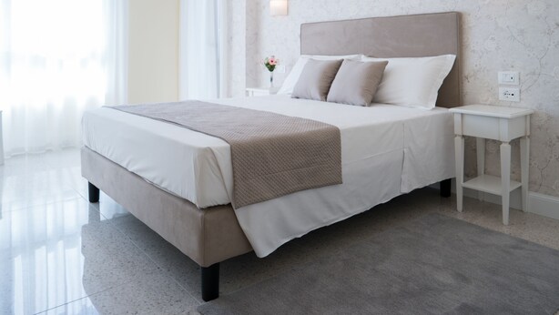 A modern bedroom with a large bed, a bedside table, and a nightstand. - Guest House Train Station (Mestre)