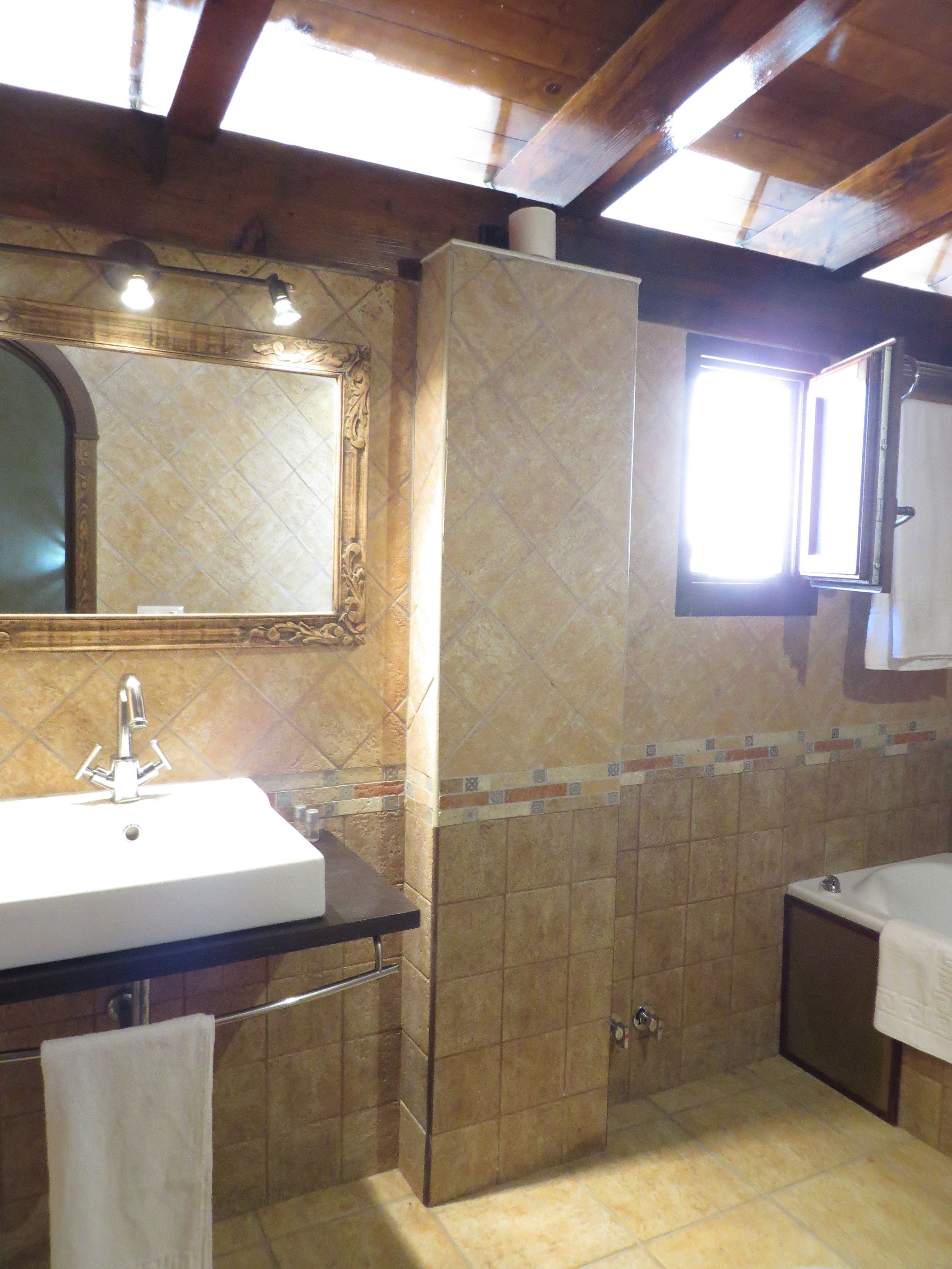 A bathroom with a sink, mirror, and window.