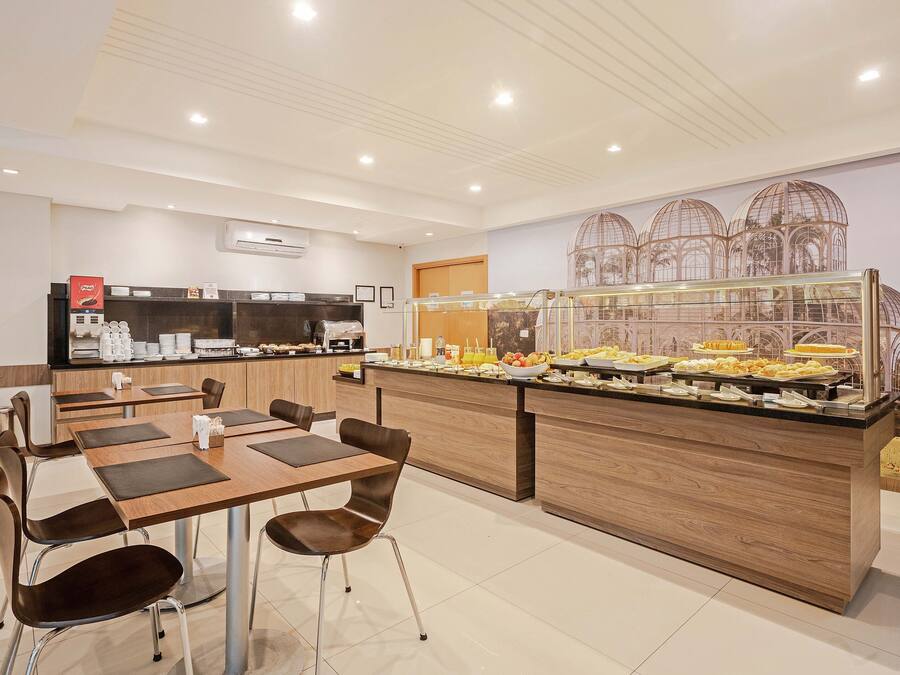 Un área de desayuno moderna con bufé, asientos y una pared decorativa.