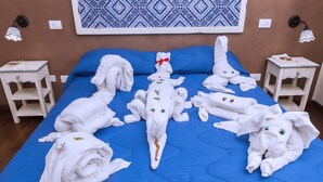 A bed with blue bedding and multiple white towels arranged in various shapes. - Stupor Mundi Bed and Breakfast (Palermo)