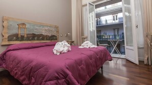 A room with a bed, a painting on the wall, and a balcony with a view. - Stupor Mundi Bed and Breakfast (Palermo)