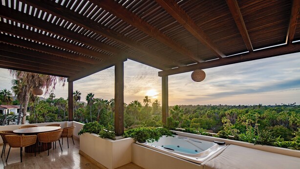 A rooftop terrace with a wooden pergola, a hot tub, and a dining area with wicker chairs. - Hacienda Todos Los Santos (Todos Santos)