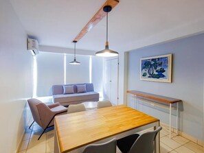 A modern dining area with a wooden table and chairs, a bench, and pendant lighting. - Balcon del Alferez (Xalapa)
