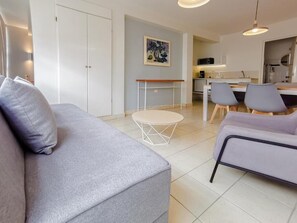 A modern living room with a grey sofa, a round coffee table, and a dining area with chairs. - Balcon del Alferez (Xalapa)