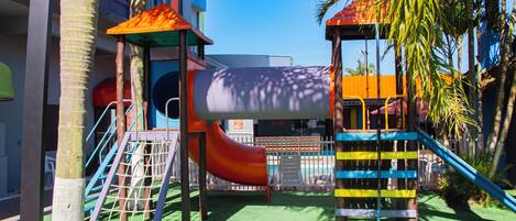 A playground with a slide, climbing structures, and a covered play area.