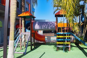 Un parque infantil con un tobogán, estructuras de escalada y una zona de juegos cubierta.
