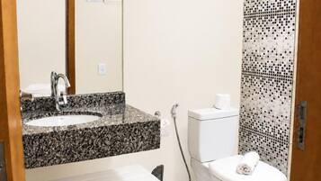 Une salle de bain comprenant un lavabo, des toilettes et un espace douche.