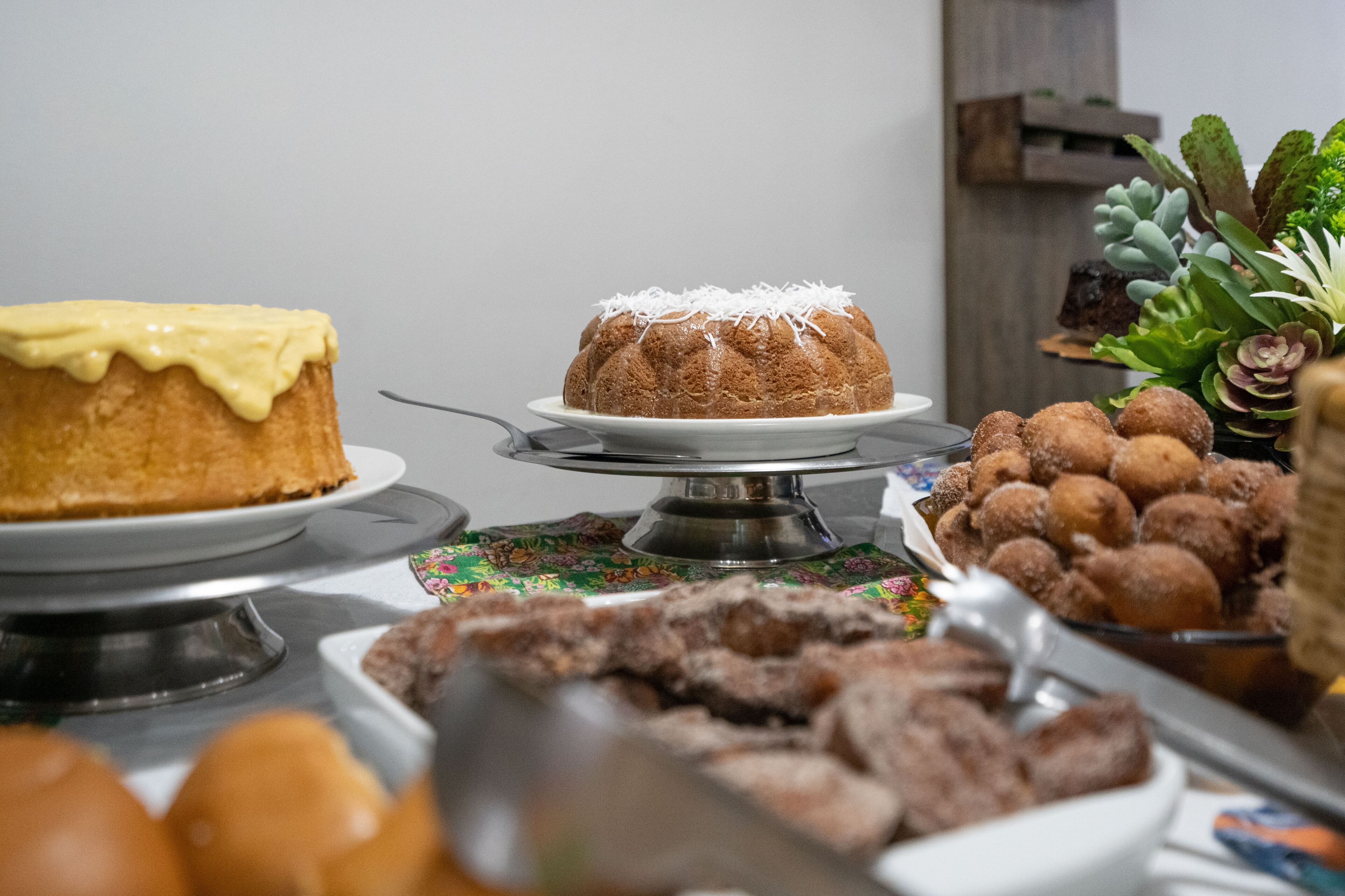 Un buffet proposant une variété de desserts, notamment un gâteau en forme de couronne, des pâtisseries et des beignets.