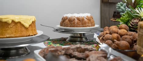 A buffet with various desserts including a bundt cake, pastries, and doughnuts.