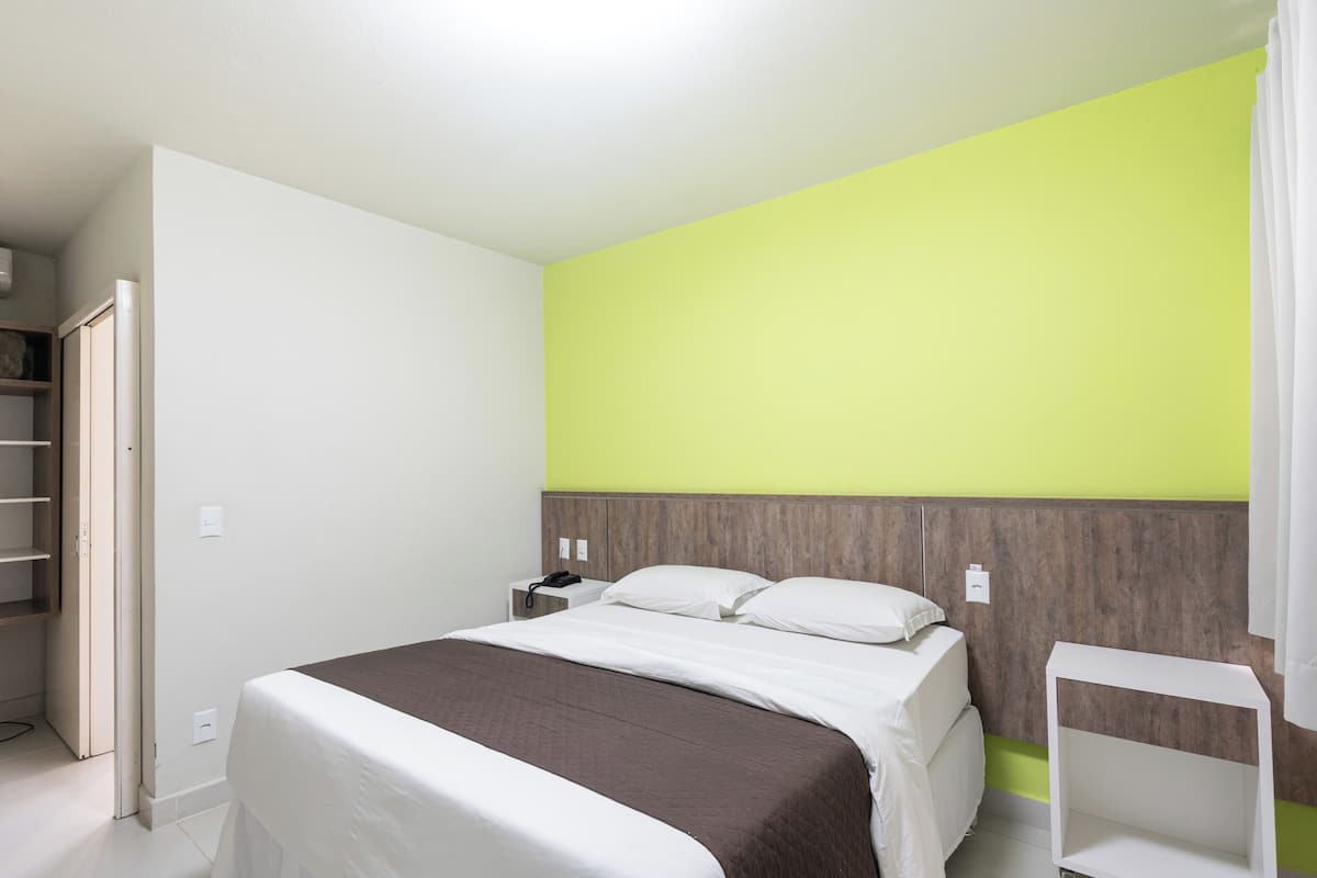 A bedroom with a bed, bedside table, and a nightstand.