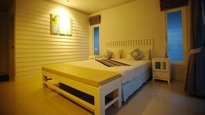 Un dormitorio con cama, mesita de noche y mesita auxiliar.