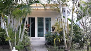 A house with a front porch, a sliding glass door, and a small step leading to the entrance. - P.P. Blue Sky Resort (Ko Phi Phi)