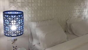 A room with a white sofa, a decorative wall panel, and a blue patterned lamp. - P.P. Blue Sky Resort (Ko Phi Phi)