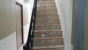Uma escadaria de mármore com corrimão de metal que leva a um patamar.