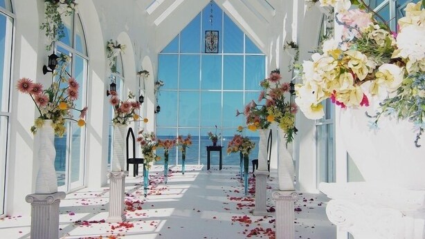 A sunlit interior with a clear view of the sea, featuring white columns, flower arrangements, and a high ceiling. - Coral Lagoon Fiji Resort (Korolevu)