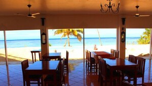 A restaurant with a beach view, featuring tables and chairs arranged for dining. - Coral Lagoon Fiji Resort (Korolevu)