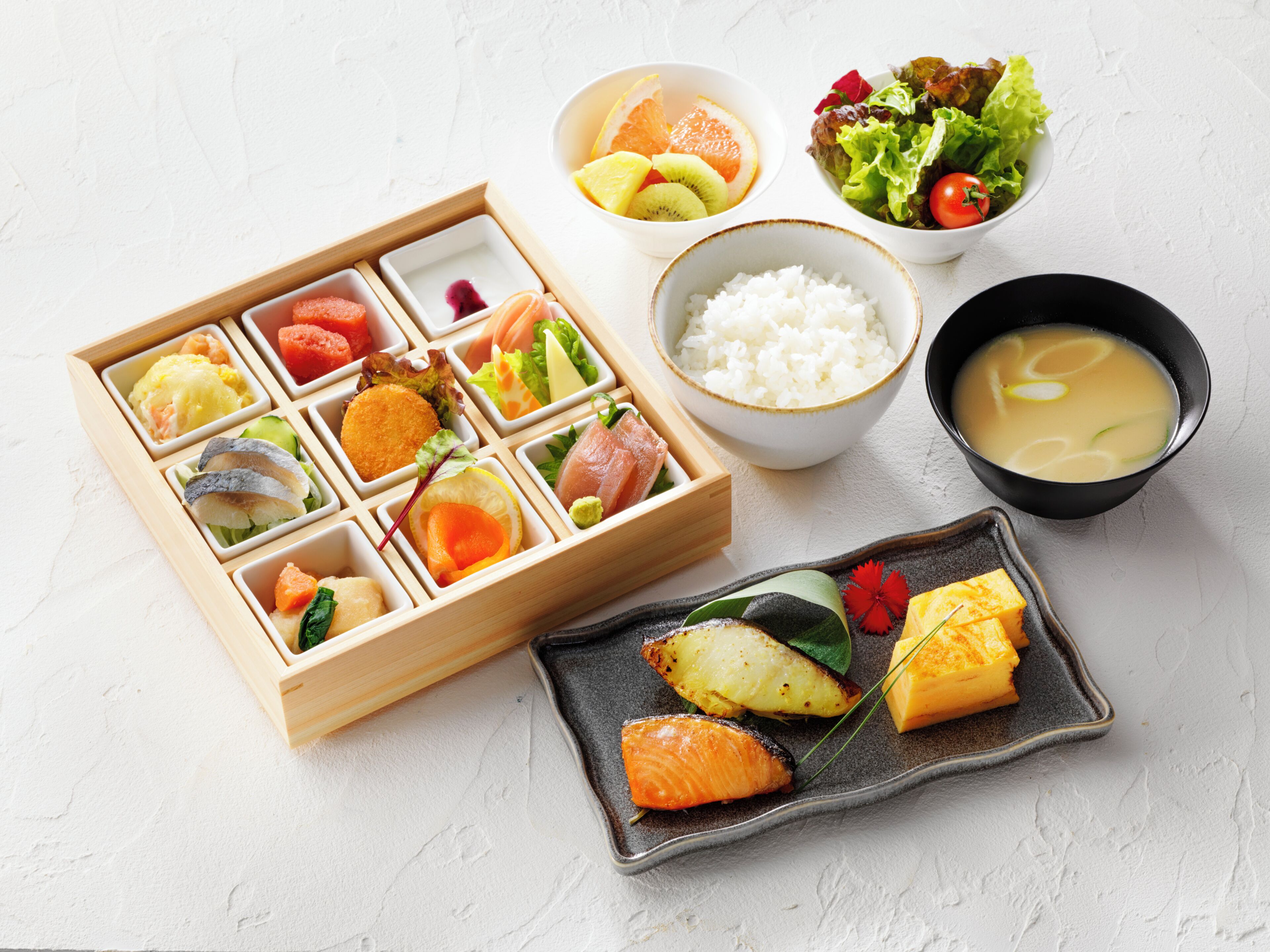 Een maaltijd met diverse gerechten, waaronder rijst, soep en een bento-box.