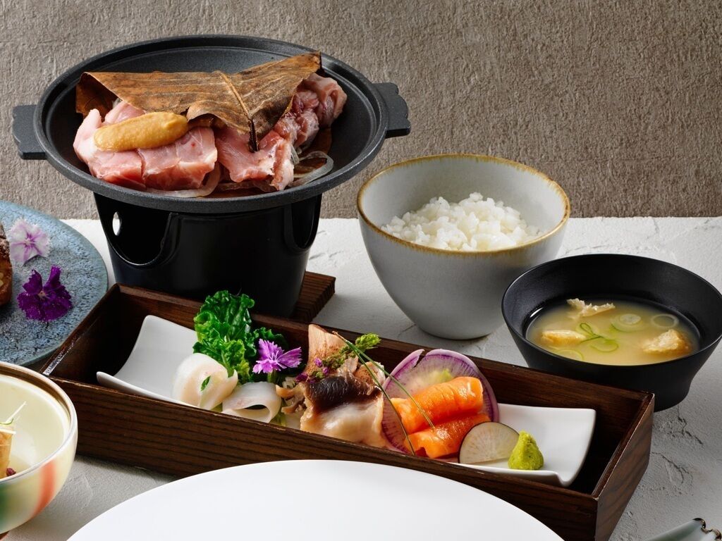 A traditional Japanese meal setup with a hot pot, rice, and various side dishes.