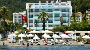 A hotel named "Casa De Maris" with a beachside location, featuring multiple balconies, umbrellas, and a flag. - Casa De Maris Spa & Resort Hotel -  Adult Only +16 - All inclusive (Marmaris)