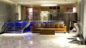 A modern lobby with a staircase, leather sofas, a metal chair, and a polished floor. - Casa De Maris Spa & Resort Hotel -  Adult Only +16 - All inclusive (Marmaris)