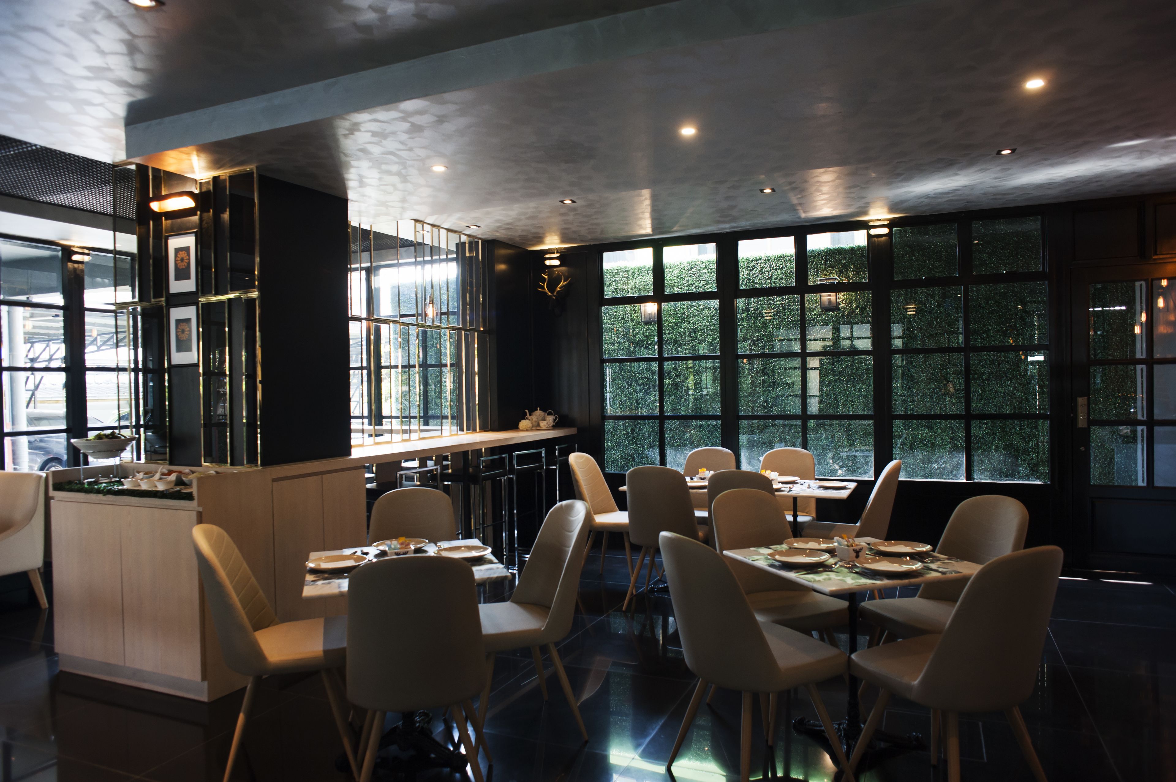 Un interior de restaurante moderno con una zona de bar, mesas y sillas.