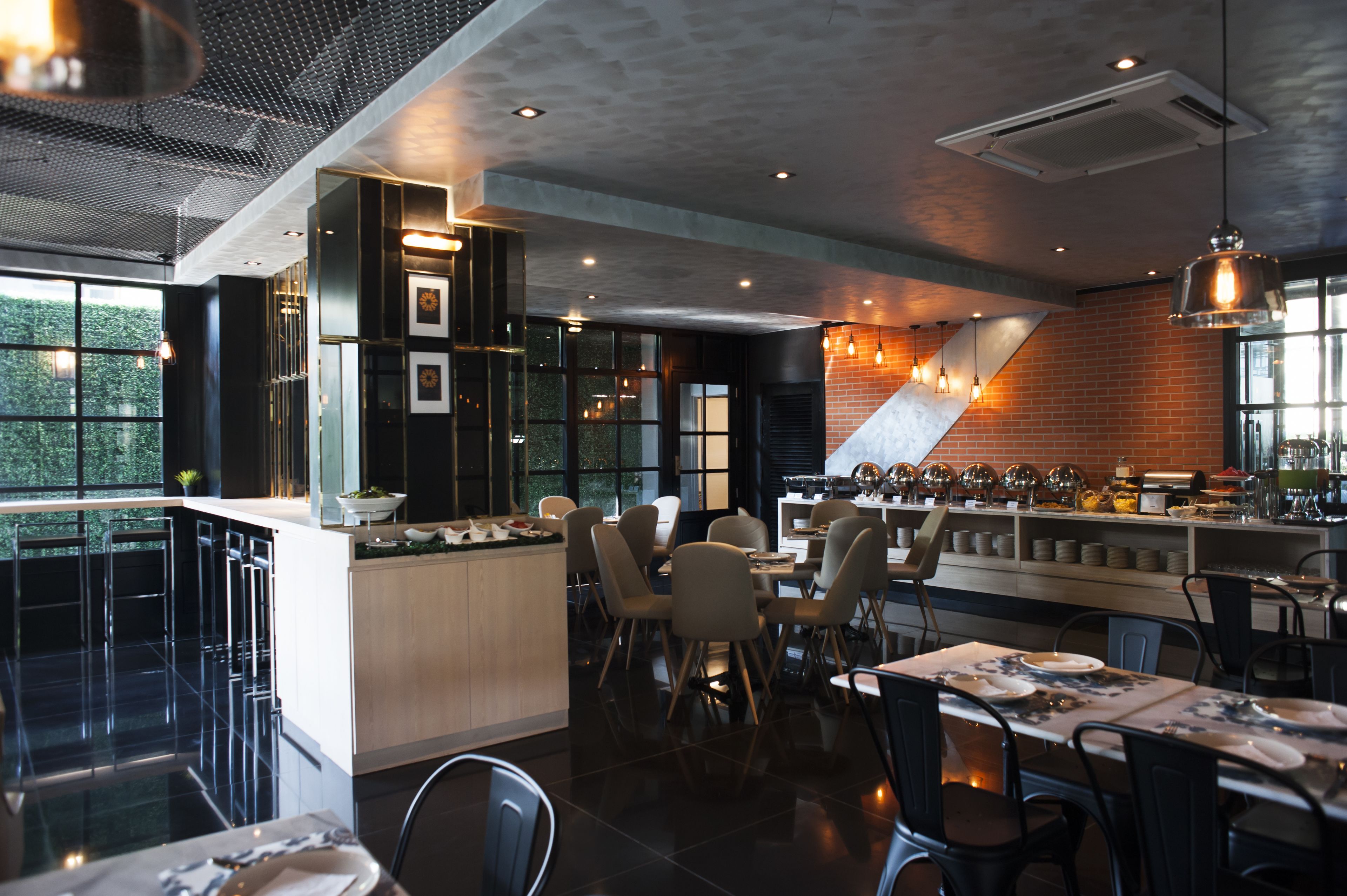 A modern restaurant with a bar area, high chairs, and a counter.