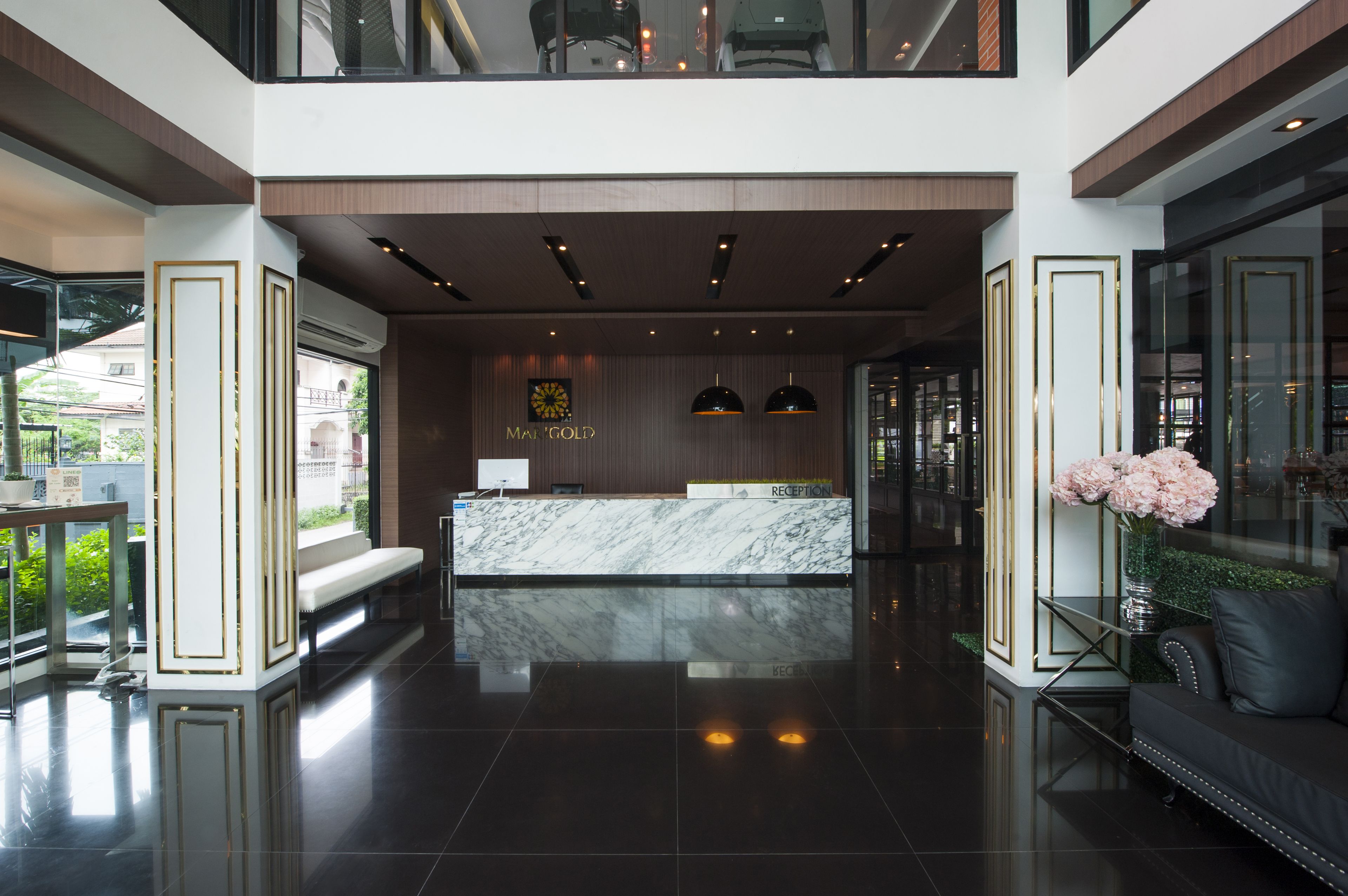 A modern reception area with a marble counter, a reception desk, and a bench.