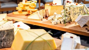 Tabla de quesos con diferentes tipos de queso y acompañamientos en un restaurante.