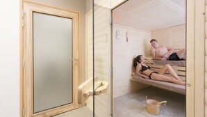Un sauna con bancos de madera y puerta de vidrio.