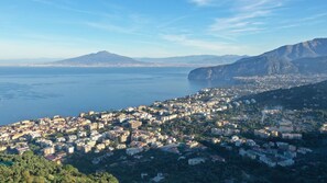 Une ville côtière, avec une montagne en arrière-plan, une vaste étendue d’eau et une urbanisation dense.