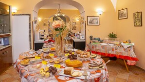 Een eethoek met een buffetbedekt met verschillende desserts en een middelpunt van gedroogde graanhalmen en een roos.