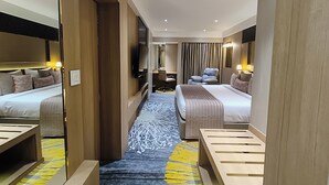 A hotel room with two beds, a desk, a TV, and a bathroom visible through a door. - Effotel by Sayaji Indore (Indore)