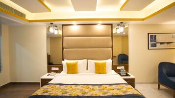 Una habitación de hotel con una cama grande, mesitas de noche, una silla y un cuadro en la pared.