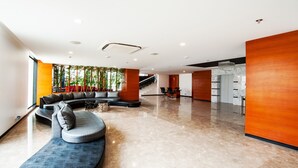 A modern lobby with a curved seating area, a staircase, and a reception desk. - Effotel by Sayaji Indore (Indore)