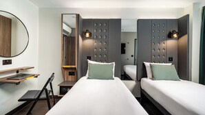 A modern hotel room with two beds, a desk, and a chair. - Point A London Canary Wharf  (London)