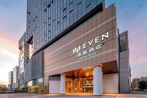 Un moderno edificio de hotel con un cartel llamativo que dice 'MEVEN'.
