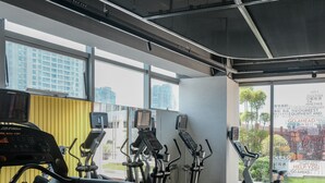 A gym with cardio machines, a treadmill, and a mirrored wall. - EVEN Hotel Hangzhou Yintai City by IHG (Hangzhou)