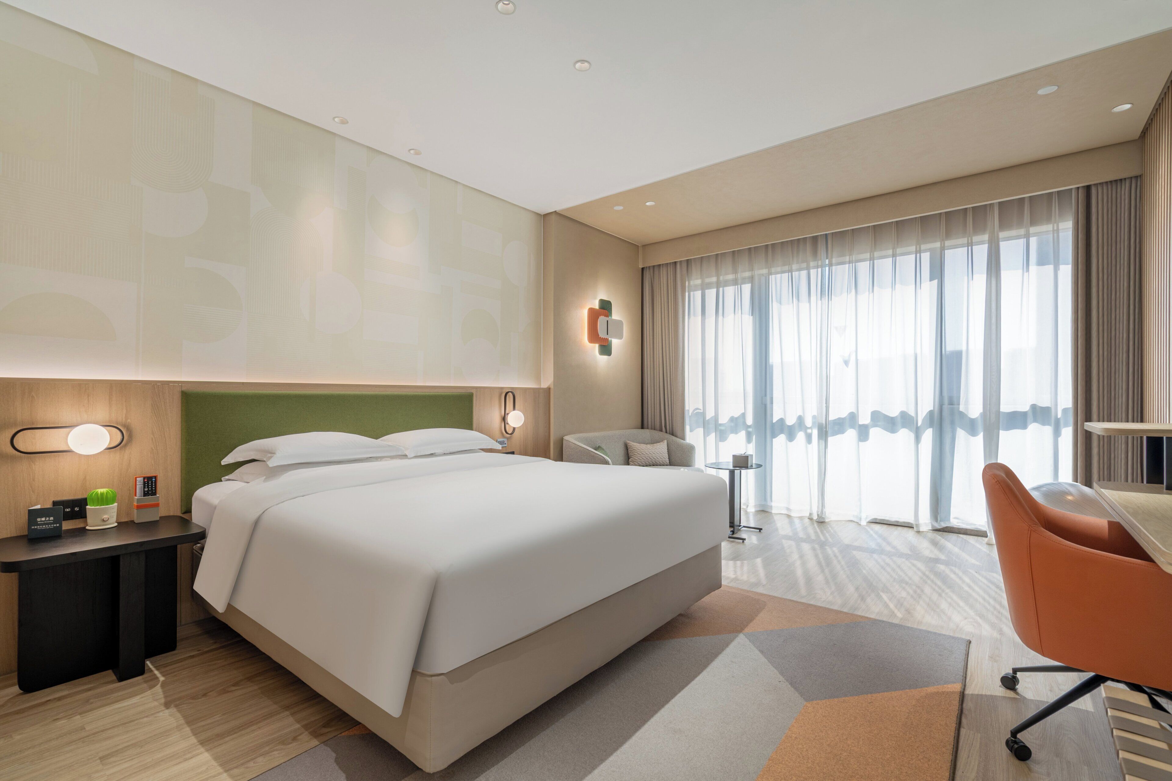 Una camera d'albergo con un letto grande, una scrivania, una sedia e vista sull'esterno dalla finestra.