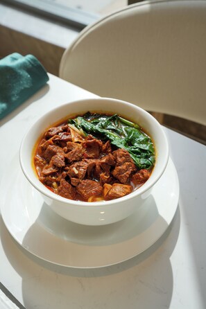 Un plato de sopa en un plato blanco sobre una mesa.