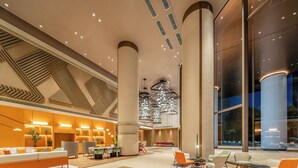 A spacious lobby with high ceilings, a central column, and a modern chandelier. - EVEN Hotel Hangzhou Yintai City by IHG (Hangzhou)