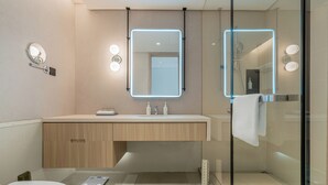 A modern bathroom with a toilet, a vanity with a mirror, and a shower area. - EVEN Hotel Hangzhou Yintai City by IHG (Hangzhou)