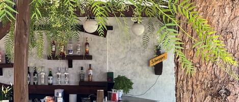A bar area with stools, a counter with bottles, and a sign reading "Schweppes".