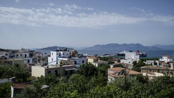 A coastal town with buildings, a marina, and mountains in the background.