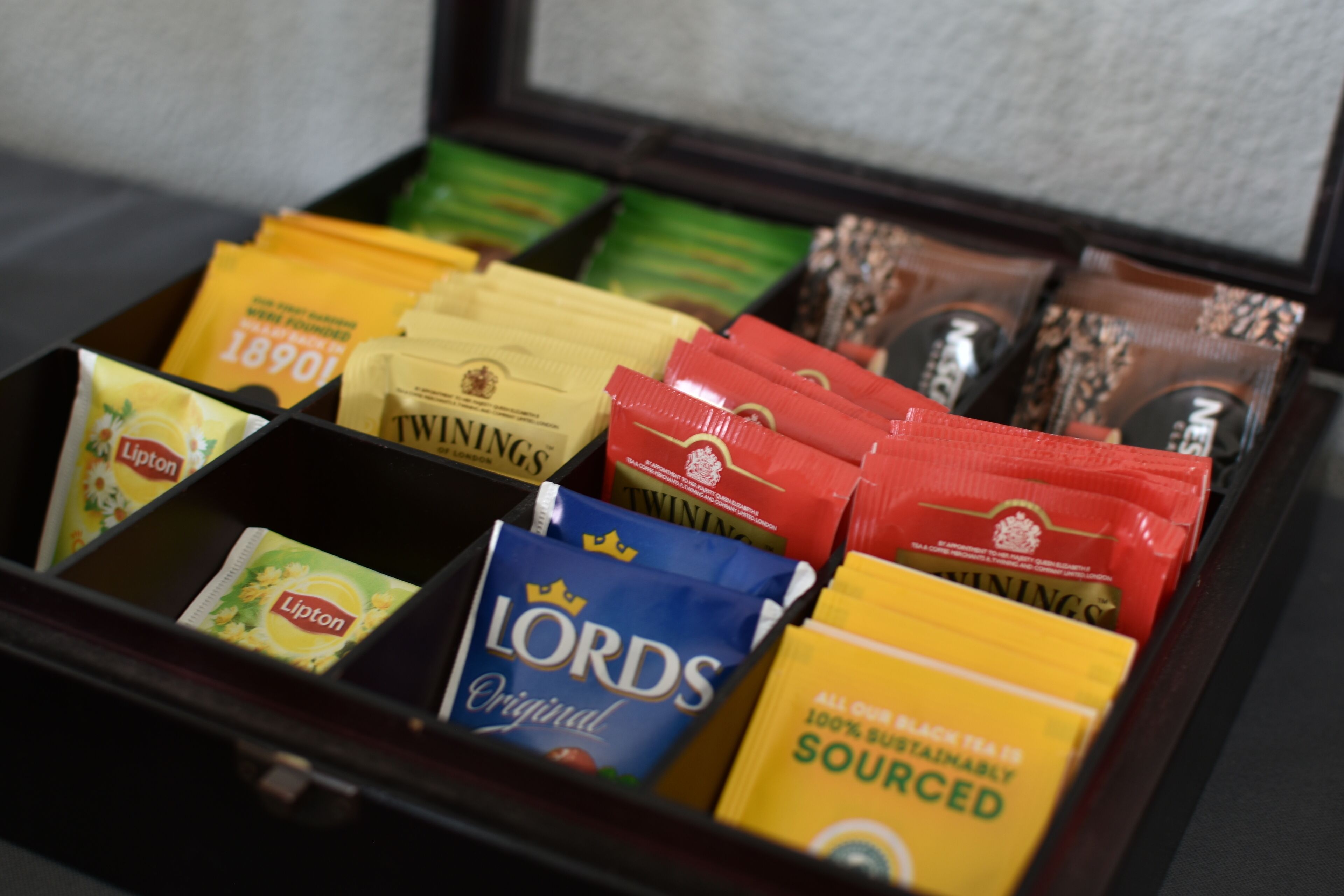 A box of assorted tea bags including Lipton, Twinings, and Nescafé.