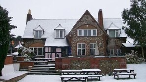 A two-story building with a stone facade and a pitched roof. - The William IV (Norwich)