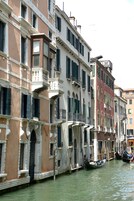A canal with buildings on either side, featuring balconies and windows.