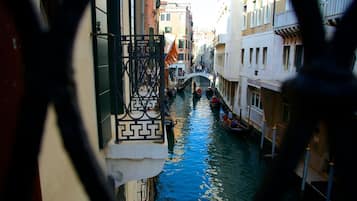 A narrow canal with boats, a bridge, and buildings on either side.