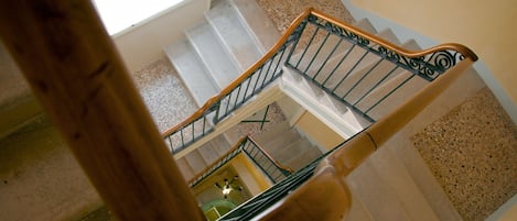 Un escalier à plusieurs niveaux, doté de rampes en bois et de balustrades en métal.